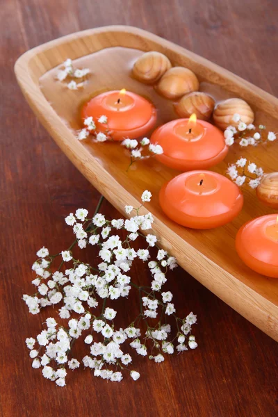 Belas velas na água na mesa de madeira close-up — Fotografia de Stock