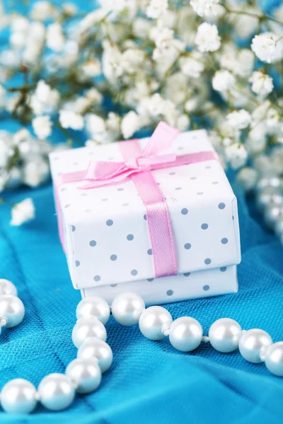 Flowers and gift on blue cloth — Stock Photo, Image