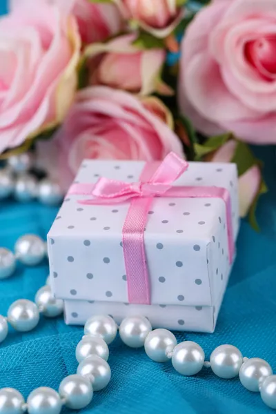 Rose en gift op blauw doek — Stockfoto