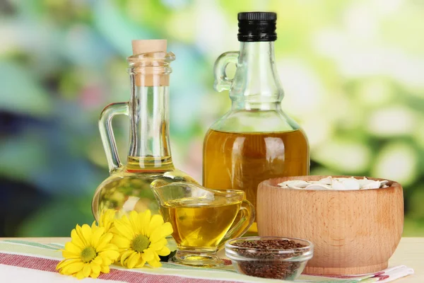 Nuttige lijnolie en pompoenpitten olieverf op houten tafel op natuurlijke achtergrond — Stockfoto