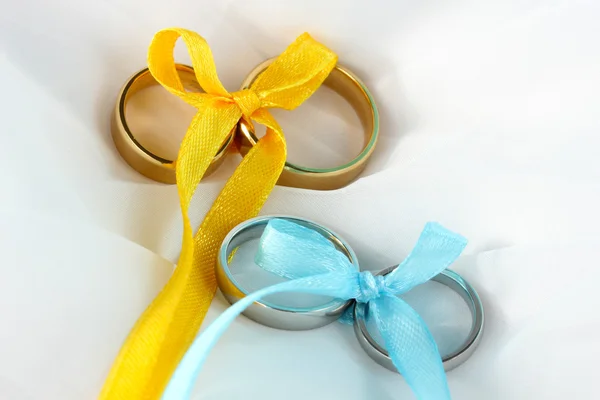 Wedding rings tied with ribbon on cloth background — Stock Photo, Image