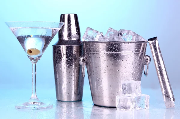 Metalen ijsemmer en shaker en cocktail op blauwe achtergrond — Stockfoto