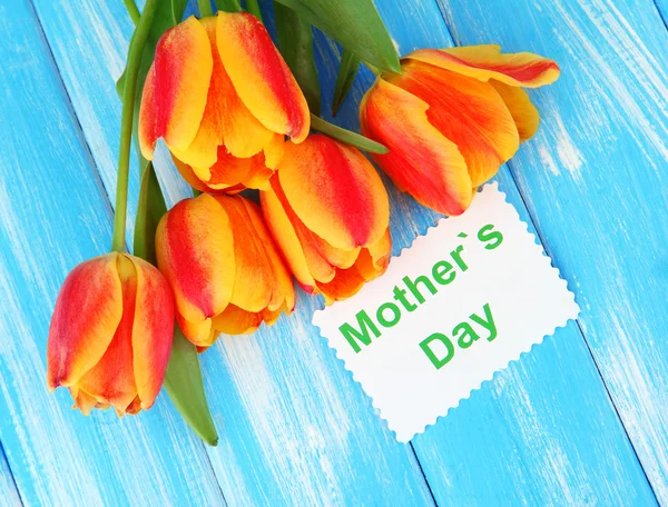 Beautiful orange tulips on color wooden background — Stock Photo, Image
