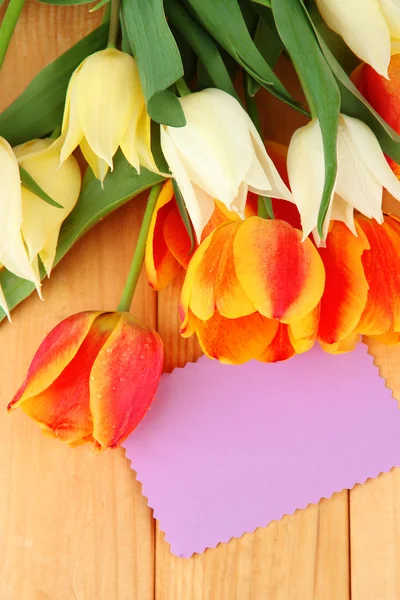 Schöne weiße und orangefarbene Tulpen auf Holzgrund — Stockfoto