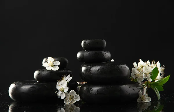 Piedras de spa y flores blancas aisladas en negro — Foto de Stock