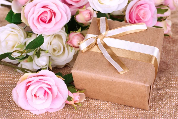 Hermoso regalo sobre fondo de flores — Foto de Stock