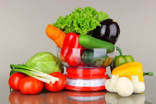 Fresh vegetables in scales on gray background — Stock Photo, Image