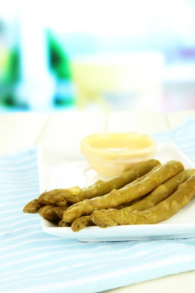 Asperges op plaat, op houten tafel op lichte achtergrond — Stockfoto