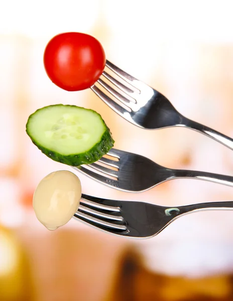 Cherry tomato, mushroom and cucumber slice sticking on forks, on bright background — Stock Photo, Image