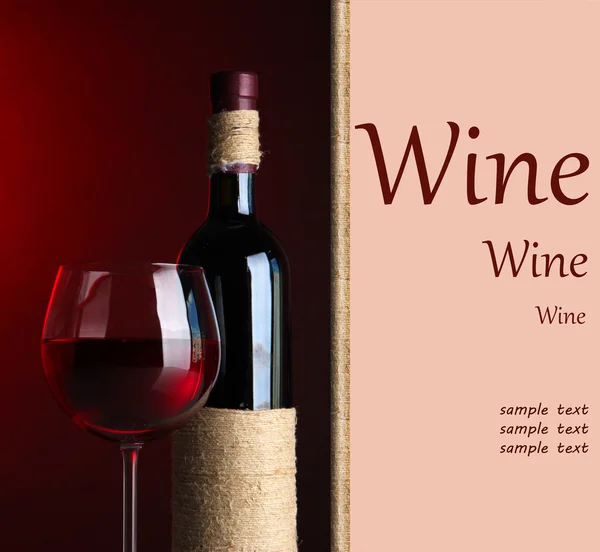 Garrafa e vidro com vinho no fundo vermelho escuro — Fotografia de Stock