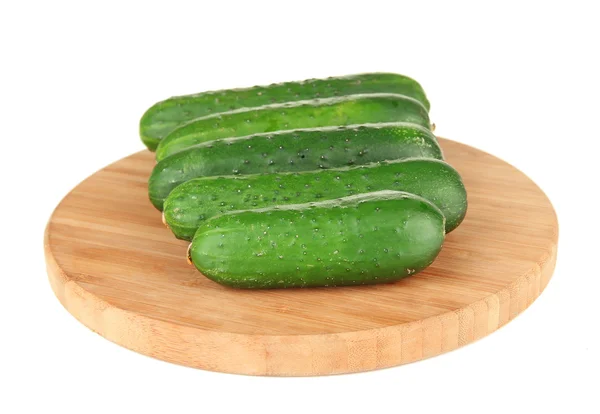 Chutné zelené okurky na dřevěné prkénko, izolované na bílém — Stock fotografie