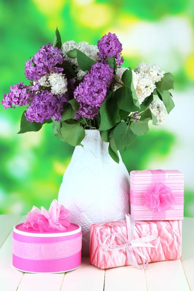 Hermosas flores lila, sobre mesa de madera sobre fondo brillante — Foto de Stock