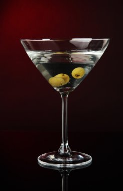 koyu kırmızı zemin üzerine zeytinli martini cam