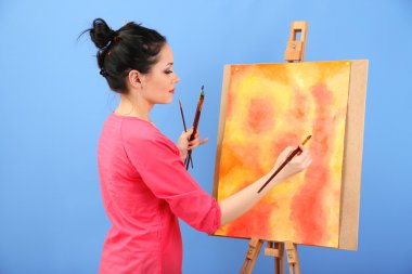 güzel bir genç kadın ressam anda, renkli arka plan üzerinde