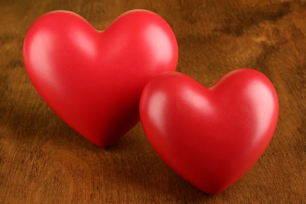 Decorative red hearts on color wooden background — Stock Photo, Image