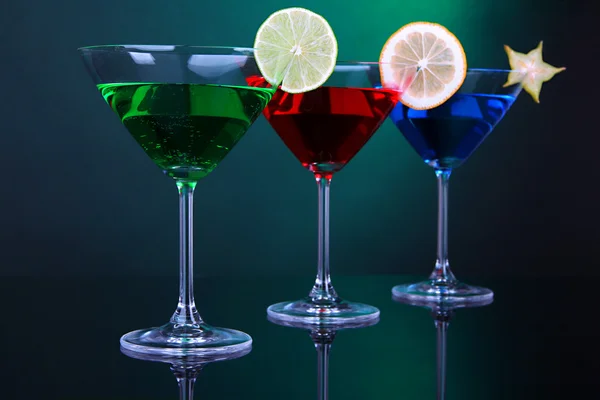 Coquetéis alcoólicos em copos de martini em fundo verde escuro — Fotografia de Stock