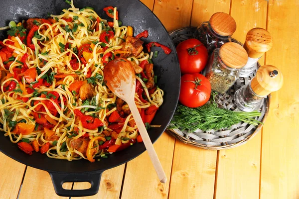 Noodles with vegetables on wok on wooden background — Stock Photo, Image