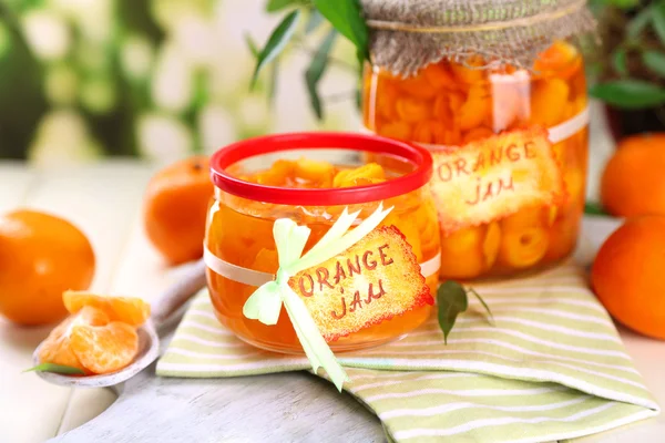 Confiture d'orange avec zeste et mandarines, sur table en bois blanc — Photo