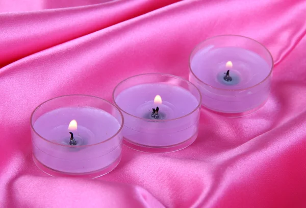 Candles on purple fabric close-up — Stock Photo, Image