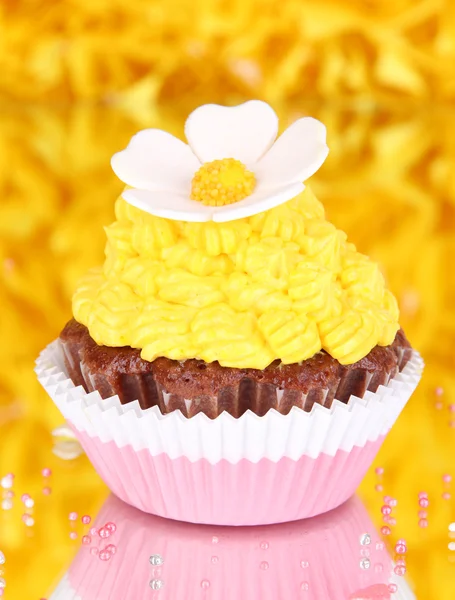 Вкусный красивый кекс на декоративном желтом фоне — стоковое фото