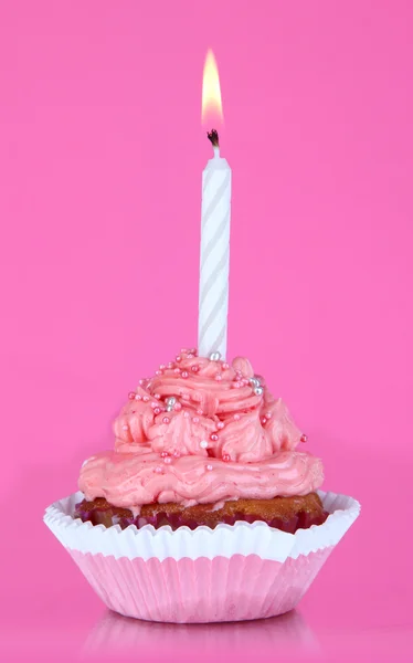 Belo cupcake com vela no fundo rosa — Fotografia de Stock