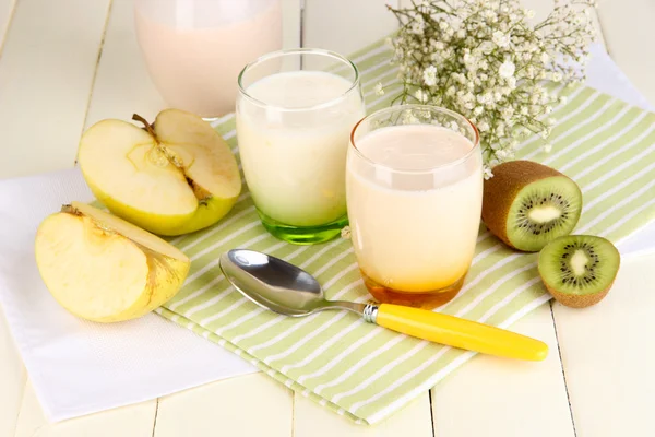 Iogurtes deliciosos com frutas em óculos na mesa de madeira close-up — Fotografia de Stock