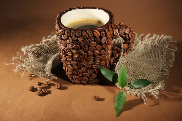 Xícara de grãos de café, em fundo marrom — Fotografia de Stock