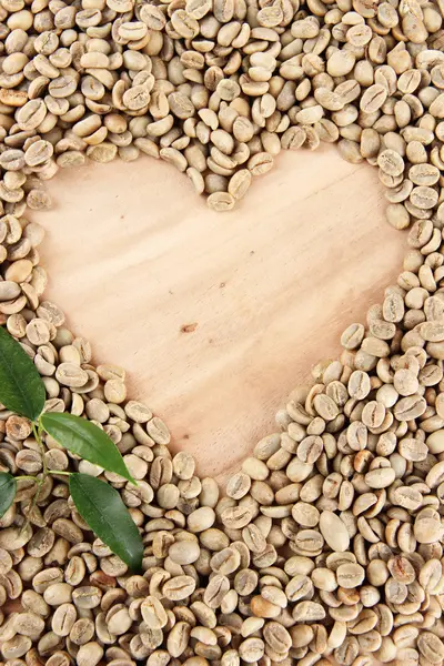 Chicchi di caffè verde e foglie su sfondo di legno — Foto Stock