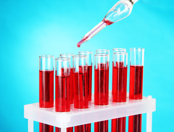 Test tubes with blood in laboratory on blue background