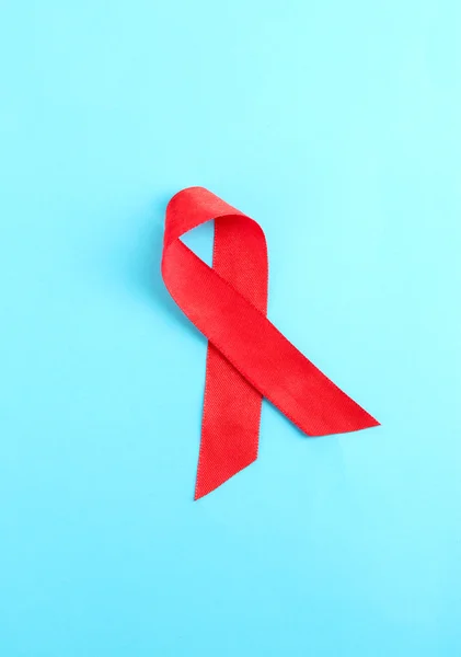 Red ribbon HIV, AIDS on blue background — Zdjęcie stockowe