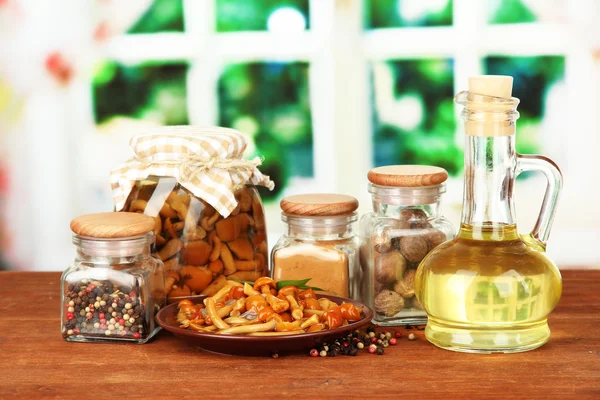 Composition of delicious marinated mushrooms, oil and spices on wooden table on bright background — Stock Photo, Image