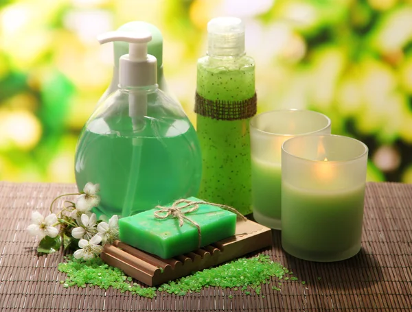 Botellas de cosméticos y jabón natural hecho a mano sobre fondo verde — Foto de Stock