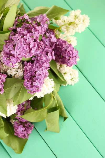 Beautiful lilac flowers, on color wooden background — Stock Photo, Image