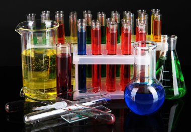 koyu arka plan üzerinde renkli test tüpleri