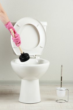 kadın bir klozet banyo unclog için bir dalgıç kullanır