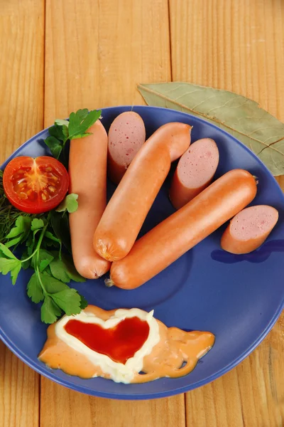 Embutidos, verduras, tomate en plato sobre mesa de madera —  Fotos de Stock