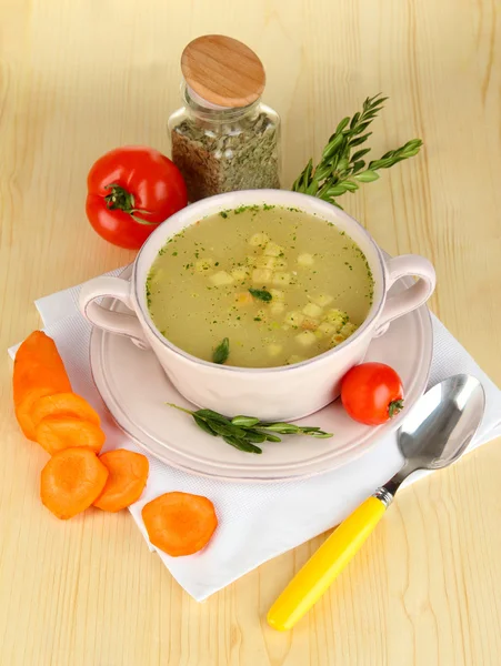 Sopa nutritiva en sartén rosa con ingredientes en la mesa de madera de cerca — Foto de Stock