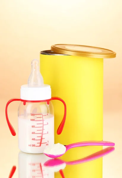 Bottle with milk and food for babies on beige background — Stock Photo, Image