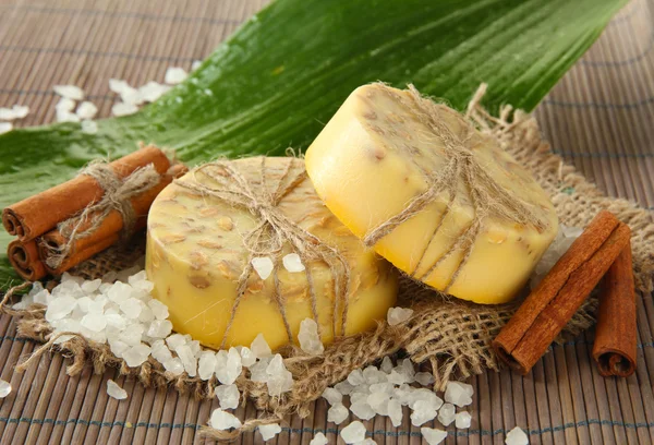 Sapone fatto a mano, sale marino e foglia su tappetino grigio di bambù — Foto Stock