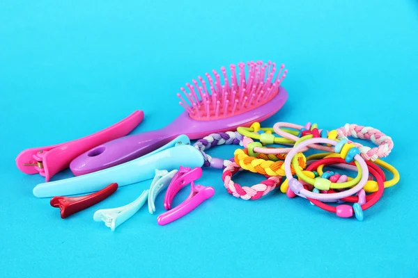 Scrunchies, hairbrush and hair - clip on a blue background — Stock Photo, Image