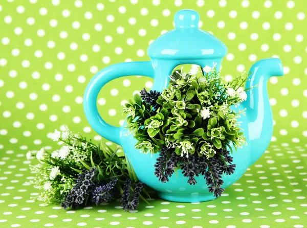 Pote com flores em um fundo de tecido verde — Fotografia de Stock