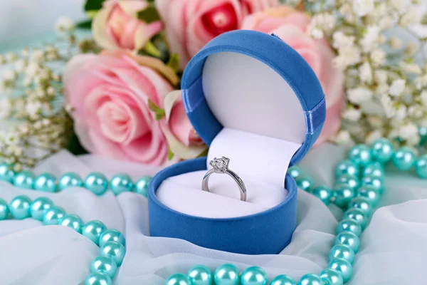 Rosas e um anel em um tecido branco — Fotografia de Stock