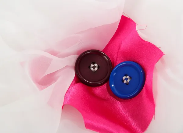 Two buttons on pink and white cloth — Stock Photo, Image