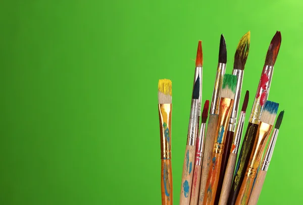 Many brush in paint on green background — Stock Photo, Image