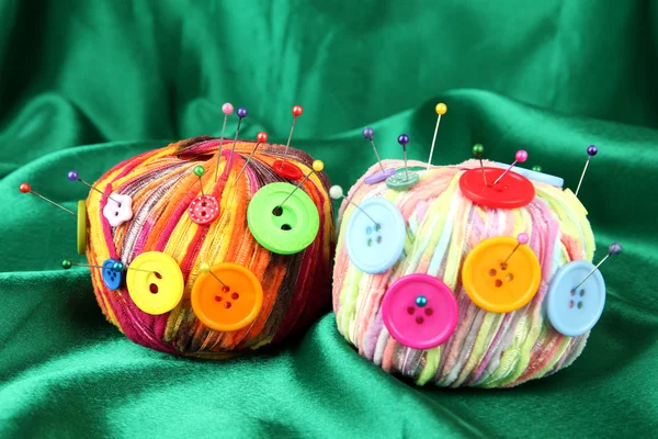 Boutons colorés et boules de laine multicolore, sur fond de tissu couleur — Photo