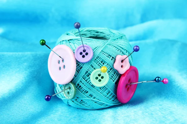 Colorful buttons and wool ball, on color fabric background — Stock Photo, Image