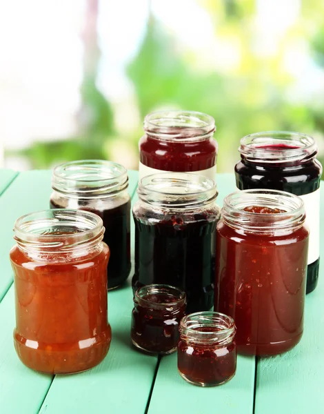 Leckere Marmelade in Banken auf Tisch vor hellem Hintergrund — Stockfoto