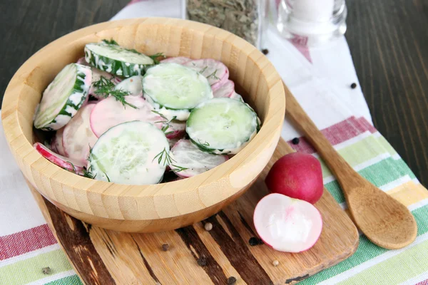 Ensalada de verduras con vitaminas en un tazón de madera sobre una mesa de madera —  Fotos de Stock