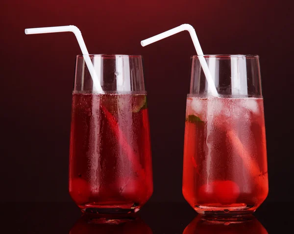 Dos cócteles de cereza con hielo sobre fondo rojo oscuro — Foto de Stock