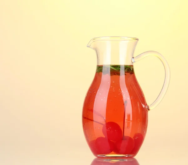 Cherry drink v džbánu na žluté poza — Stock fotografie